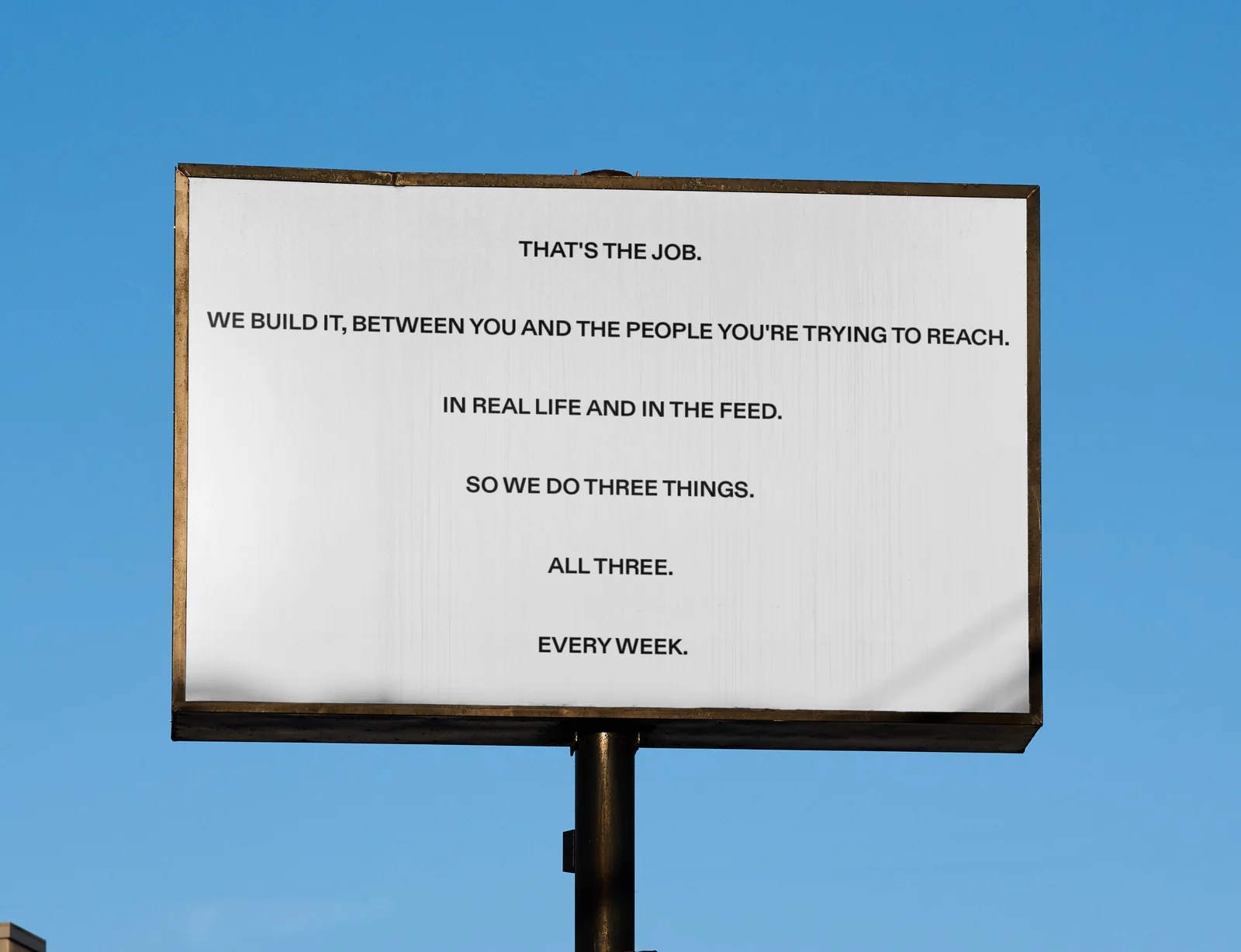 A Yes billboard against a blue sky: That's the job. We build it, between you and the people you're trying to reach. In real life and in the feed. So we do three things. All three. Every week.